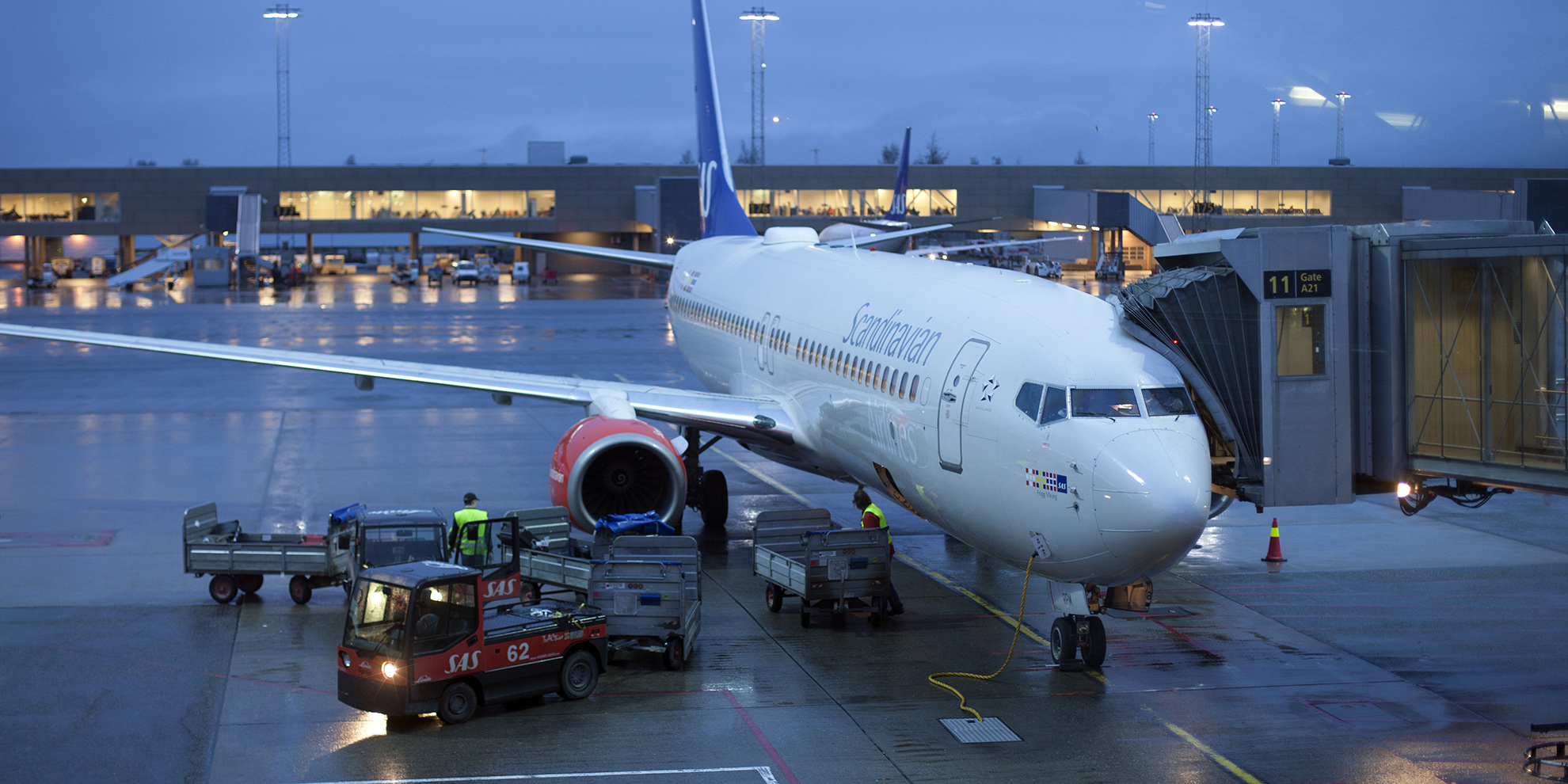 SAS-fly ved gate på Gardermoen i skumring